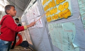 A young Syrian boy, studying both Arabic and Roman alphabets. Photo: Concern Worldwide.