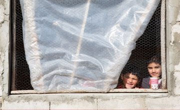 Syrian refugee Afaf, 8, and her younger brother Hani, 4, stand by the window of the kitchen in the collective shelter where they live with their family in Akroum, in Akkar, north Lebanon. Photo: Dalia Khamissy / Concern Worldwide.
