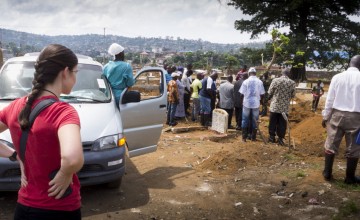 An observer from the Center for Disease Control (CDC) watches as a short graveside ceremony takes place at Kingtom cemetery in Freetown. Photo: Kieran McConville / Concern Worldwide.