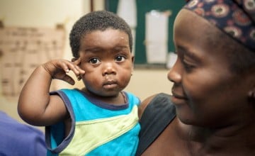 Memuniatu Kamara with her young child at the Allen Town PHU in Freetown, Sierra Leone. Photo taken by Michael Duff / Concern Worldwide. 