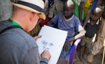 Irish artist Brian Maguire sketches a young boy in the POC of Bentiu, South Sudan. Photo: Steve De Neef / Concern Worldwide.