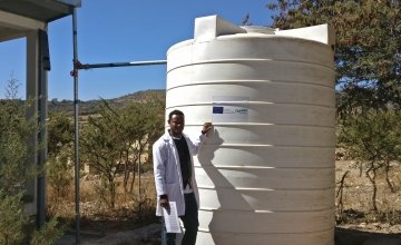 Gedyan Tesfay, Director of the health centre in Tiku, Doga Temben, Ethiopia, beside a water harvesting tank. Photo: Concern Worldwide. 