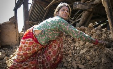 In a Nepalese village, Chandra stands amongst the wreckage of her home. Photo taken by Crystal Wells/Concern Worldwide.