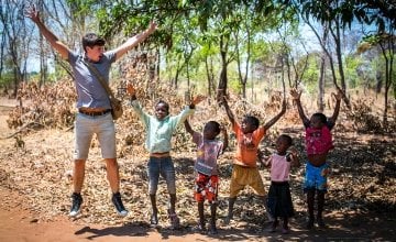 TV cook and writer Donal Skehan jumping for joy with children of Jambawe village, where Concern provided a bike ambulance. Photo: Concern Worldwide.