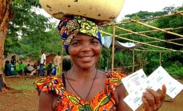 Wiligala Isabelle from Kenenge village is pictured holding her vouchers used to purchase seeds and tools at a seed fair organised by Concern. Photo: Concern Worldwide.