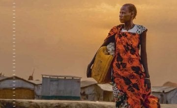 A woman walks to collect water early in the morning at a camp for IDPs in Bentiu, South Sudan, 2018. Photo: Welthungerhilfe/Stefanie Glinski.
