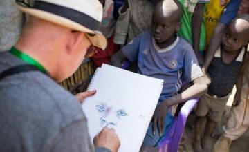 Brian Maguire sketches a young boy in the PoC camp in Bentiu, South Sudan. Photograph: Steve De Neef/Concern Worldwide