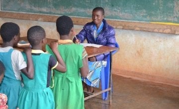 Mercy Mwadula marking her learners exercise in class as they await their turns to be marked. Photo: Concern Worldwide.