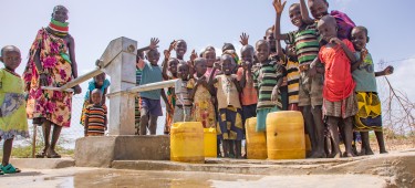 Regina Ekiru (30) and some children from Kadak Aikeny village, Turkana, Kenya at a well that Concern rehabilitated. May 2022. Photo: Gavin Douglas/Concern Worldwide.