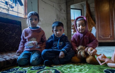 Khaled and Maram's children sit on floor of the building they live in