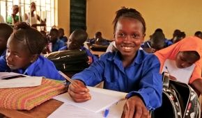 Mariatu, a student in Sierra Leone, writing in classroom