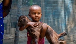 Rakib holds a goat provided to his mother in Bangladesh