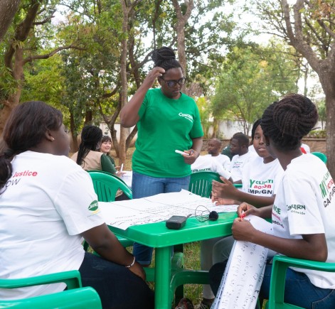 Group of climate activists sitting at table discuss climate change at Concern's Malawi office