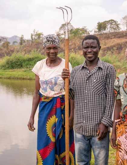 Farmer Kosimasi and two workmates at their pond in Samu village