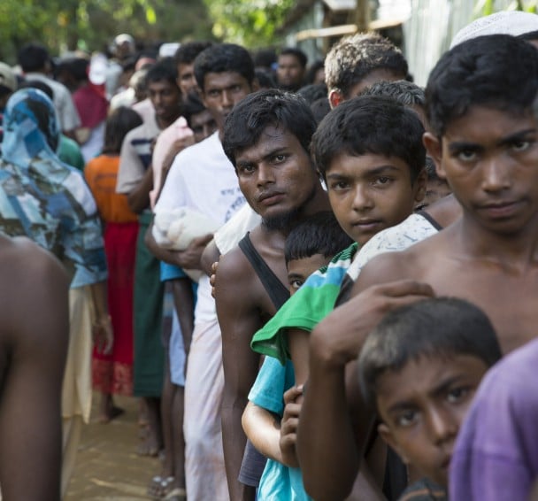Rohingya men from Myanmar queue at a distribution site at Hakim Para in Cox's Bazar, Bangladesdh. Photo: Kieran McConville / Concern Worldwide.
