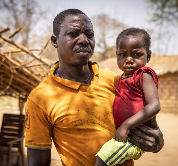 Central African man holding infant child 