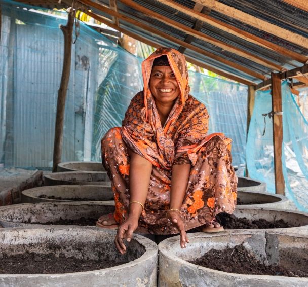 Asma Begum pictured with the compost she has made thanks to training in climate smart agricultural techniques