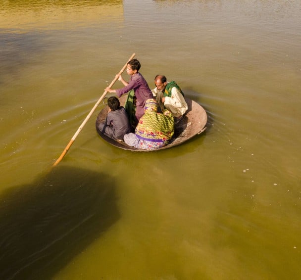 Young boy ferries people across Pakistan floods on curry frying pan