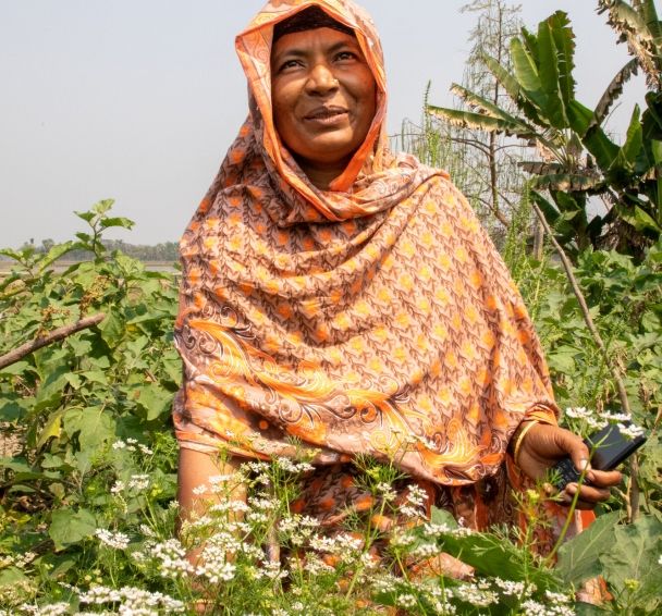 Asma Begum shows off crops she is growing on her farm in Bangladesh