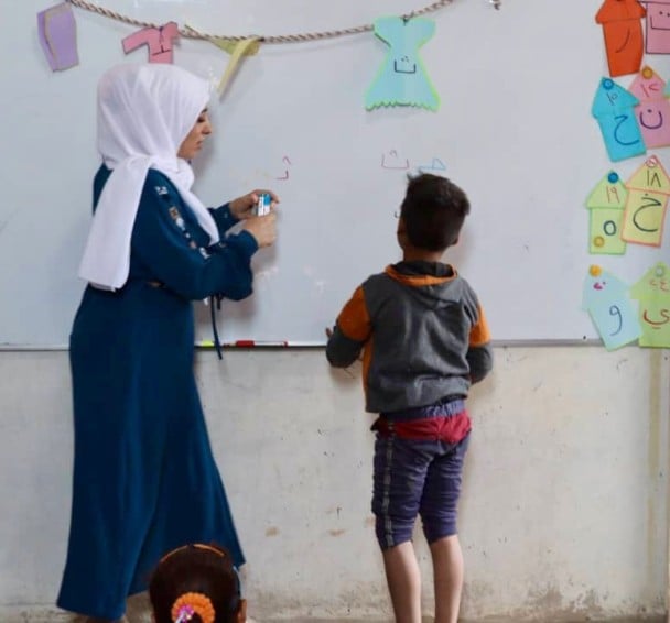 Hani (name changed) writing on blackboard in school