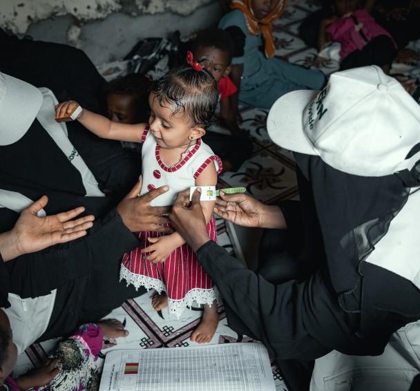 Community Health Volunteer (CHVs) conducting nutrition screening on a child in Yemen.
