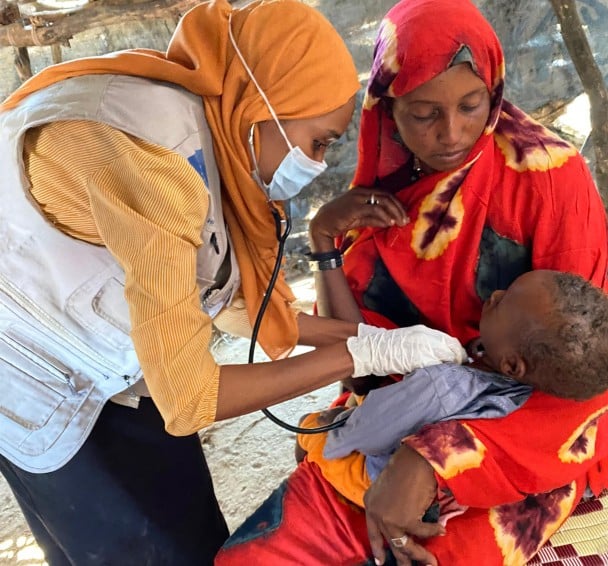 Hanafy Omer Abdalla (17 months) receives a check up with his mother Islam Ahmed Abdalla (28)