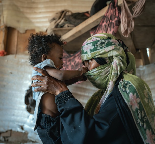 Basam being held by his mother