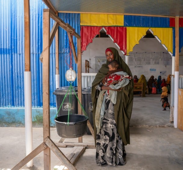 Hoodo* with 8-month-old Mulki* at a Concern-supported clinic near Mogadishu, where they traveled after attacks on their home village killed Hoodo's husband. “I knew my baby was sick, but I did not know where to take her because I feared being given medication I could not afford. Fortunately, the health workers from Concern visited the camp, saw my child, tested her, and gave her the RUTF and some medication to help with her symptoms.” Photo: Eugene Ikua/Concern Worldwide