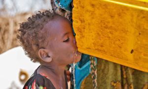 Young girl drinking from a tippy-tap in Somalia