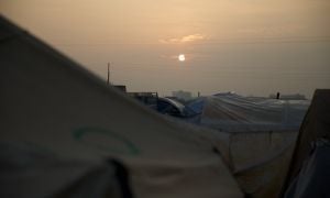Sun rising over tents in north west Syria