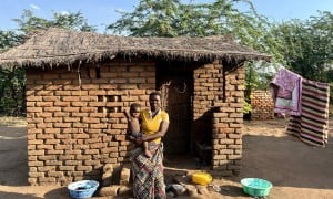 Eliza holds her baby outside her home in Bitilinyu camp