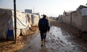 Jaafar* (32) walks through the muddy roads of Ahl al-Khair camp “The condition here is very harsh and staying in a camp is difficult, we did not have any happy occasions in the camp nor any joyful occasion. Do not think that whoever stays here will be happy &quot;This is not true. Anyone who lives here is forced to do so.&quot; Photo: Ali Haj Suleiman/DEC/Fairpicture