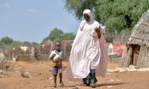 Baria Moumouni carries home packages of fortified flour with her child, distributed by Concern in Tanawara village, Niger. Photo: Concern Worldwide