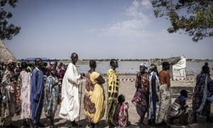 Nyepahan Ketket (in blue and yellow dress) is registered and given money in a cash distribution in Chotyiel, a settlement surrounded by flood water near Gwit, south of Bentiu in Unity State. Photo: Ed Ram/Concern Worldwide