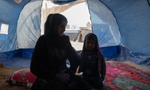 Amira* sits with her youngest child in a tent she calls home, she is one of the 11 million people who have been displaced within Syria during 15 years of conflict. Photo: Gavin Douglas/Concern Worldwide