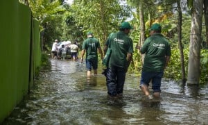 Concern Emergency response team members walk through a submerged road in Noakhali district following the 2024 Bangladesh floods. Photo: Akram Hossain/Concern Worldwide