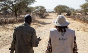 Concern staff member and representative from Irish Embassy to Sudan walk down a sandy road in Sira, Chad