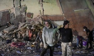 People stand at the site of a collapsed building following an earthquake in Caracas on June 25, 2026