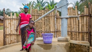 Irene with her daughter Lucy (8) and their new water pump. Photo: Gavin Douglas/Concern Worldwide.