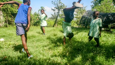 Children playing and performing handstands on the grass 