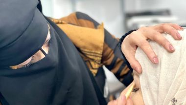Livelihoods graduate Hasa* applies makeup at her salon in Syria