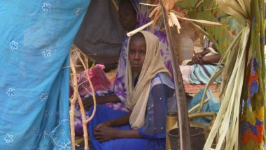 Sudanese refugee sits in makeshift tent in Chad