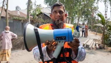 A member of the self-help committee with a megaphone for early-warning. Rangpur, Bangladesh. Photo: Gavin Douglas/Concern Worldwide