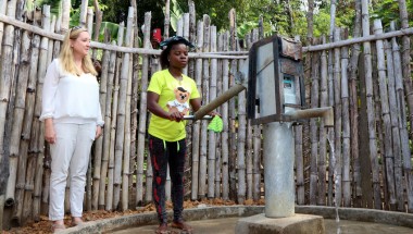 Mary Zeon, a mother group member, showcasing the newly constructed water point to the Irish Ambassador Claire Buckley and team in Tarr Town, Liberia. 