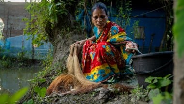 Shochi Ray sorts fish from her today’s catch, releasing the tiny ones back to the pond in Kalinagar, Kamarkhola. Photo: Mumit M/Concern Worldwide