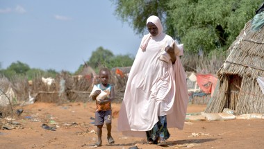 Baria Moumouni carries home packages of fortified flour with her child, distributed by Concern in Tanawara village, Niger. Photo: Concern Worldwide
