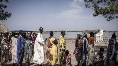 Nyepahan Ketket (in blue and yellow dress) is registered and given money in a cash distribution in Chotyiel, a settlement surrounded by flood water near Gwit, south of Bentiu in Unity State. Photo: Ed Ram/Concern Worldwide