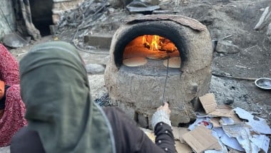 Manila* and her family were displaced to Rafah then to Al-Nuseirat in Gaza. She makes some bread with the resources they have, but they have no tent or access to food and water. (Photo: Khalil Adwan)