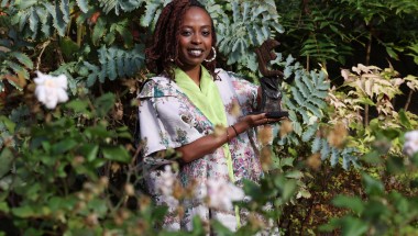 Women of Concern honouree, Berabose Aline Joyce with her award against leave backdrop