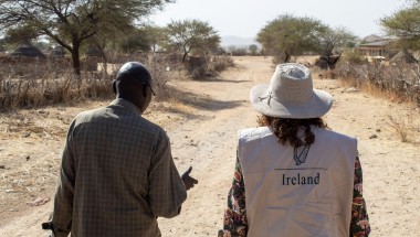 Concern staff member and representative from Irish Embassy to Sudan walk down a sandy road in Sira, Chad